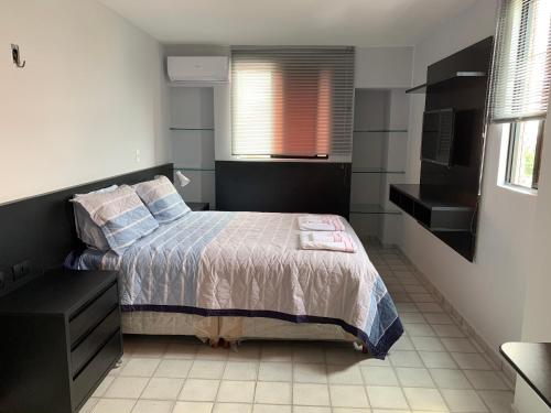 a small bedroom with a bed and a window at Apartamento amplo com acesso direto à praia! in Cabedelo