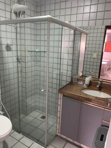 a bathroom with a shower and a sink and a toilet at Apartamento amplo com acesso direto à praia! in Cabedelo