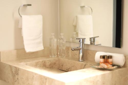 La salle de bains est pourvue d'un lavabo, d'un miroir et de serviettes. dans l'établissement VIAMONTE House Boutique, à León