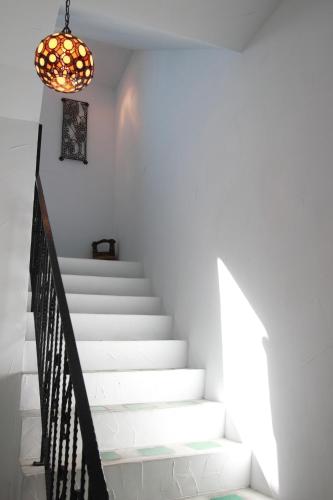a stairway with a chandelier and white stairs at Mandheling B&B in Jian