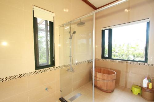 a bathroom with a shower with a wooden tub at Mandheling B&B in Jian