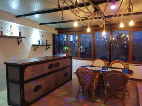 uma sala de jantar com uma mesa e cadeiras de madeira, uma mesa e uma espreguiçadeira em Ipekyolu Garden em Avanos