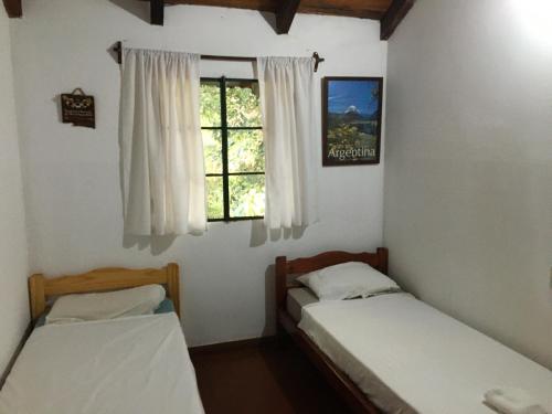 two beds in a room with a window at Zorzal 1 in Puerto Rico