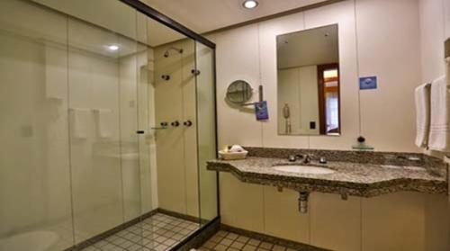 a bathroom with a glass shower and a sink at Condomínio Master Metropolitan -Centro de Brasília in Brasilia
