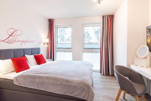 una camera da letto con un grande letto con cuscini rossi di Appartement "Froschkönig" - Oase am Haff a Garz