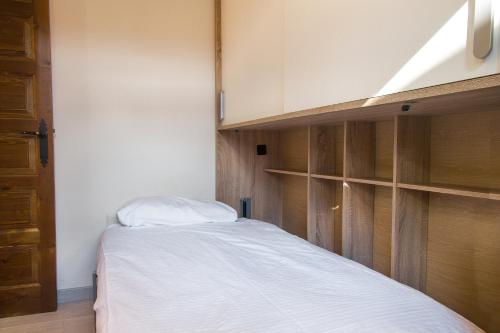 a small bedroom with a bed and wooden cabinets at Apartamento Refugi d'Incles 6 personas in Canillo