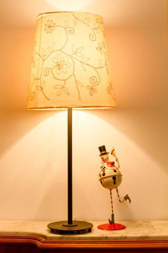 a lamp on a table with a figurine on it at Refugi d Inclès 1 habitación in El Tarter