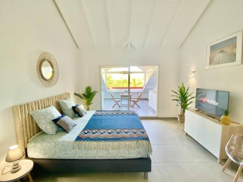 a bedroom with a bed and a television in it at Beautiful suite S18, pool, sea view, next to paradise Pinel Island in Cul de Sac