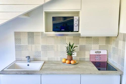 a kitchen with a sink and a pineapple on a counter at Beautiful suite S18, pool, sea view, next to paradise Pinel Island in Cul de Sac