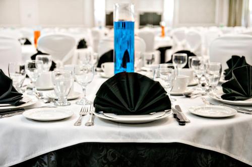 a table with a white table cloth with plates and silverware at Crowne Plaza Kitchener-Waterloo by IHG in Kitchener