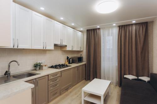 a kitchen with white cabinets and a counter top at Apart-smart on Kharkovskaya near Lavina 1 floor in Sumy