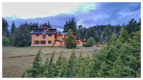 una casa grande en medio de un campo en Ailín Maiá Apartamentos Casa de Montaña en San Carlos de Bariloche