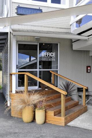 a store front with a porch and stairs in front at Accent On Taupo Motor Lodge in Taupo