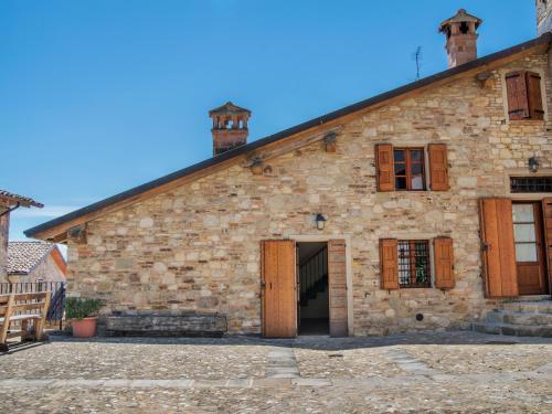 - un vieux bâtiment en pierre avec des portes et des fenêtres en bois dans l'établissement Belvilla by OYO Aia, à Castellarano