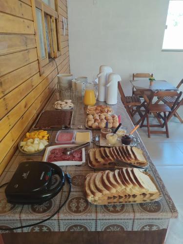 ウルビシにあるPousada da Grutaのさまざまな種類の食べ物が並んだテーブル