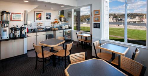 a room with tables and chairs and a kitchen with a window at South Pier Inn in Duluth