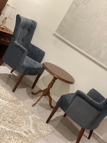 two chairs and a table in a room at فندق كنان سويت in Sulţānah