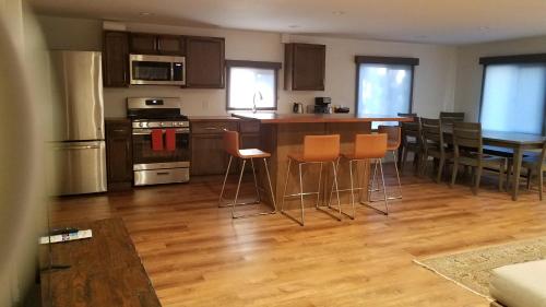 a kitchen with wooden floors and orange bar stools at Shoshone Inn in Shoshone