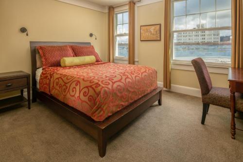 a bedroom with a bed and a desk and two chairs at Hotel Elliott in Astoria, Oregon