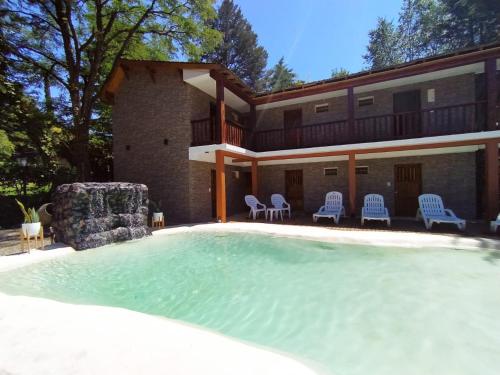 a large swimming pool in front of a house at Hotel Berlin in Villa General Belgrano