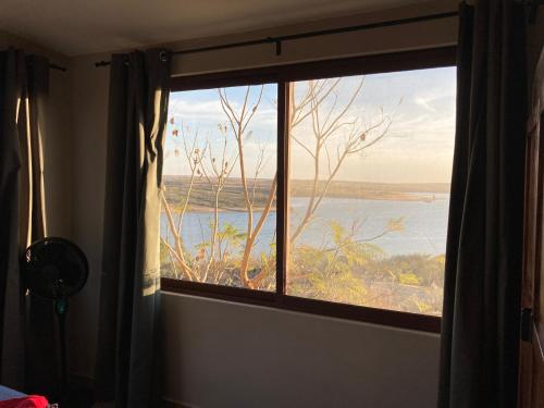 a room with a window with a view of the ocean at Gran Despertar El Faro Hotel in Santiaguillo