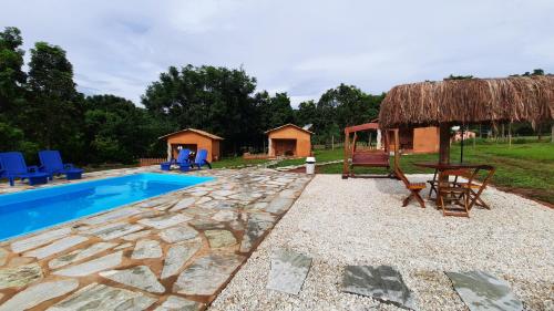 a resort with a swimming pool and a hut at Quinta do Vale in Pirenópolis