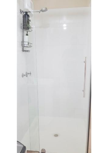 a shower with a glass door at City Escape Taroona in Taroona