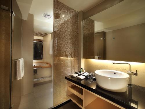 a bathroom with a sink and a shower at Sun Moon Lake Hotel in Yuchi