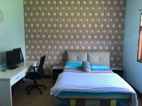 Un pat sau paturi într-o cameră la Pondok Raphael Guesthouse