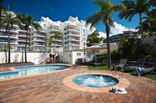 a swimming pool in front of a large apartment building at Osprey Apartments in Mooloolaba