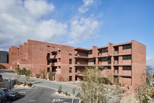 a red brick building with a parking lot at SEKIYA RESORT Galleria Midobaru in Beppu