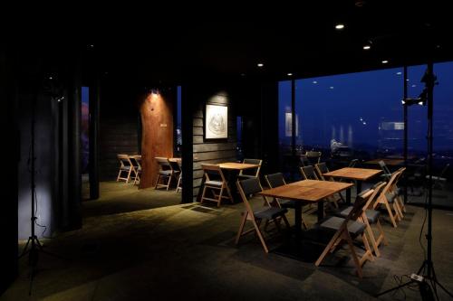 a restaurant with tables and chairs and a view of the city at SEKIYA RESORT Galleria Midobaru in Beppu