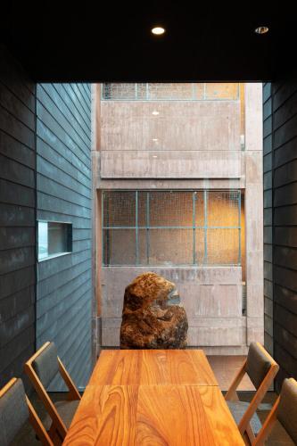 a wooden table with chairs and a large rock at SEKIYA RESORT Galleria Midobaru in Beppu
