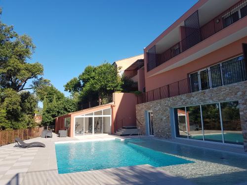 a swimming pool in front of a building at Le Mas du Lingousto in Cuers