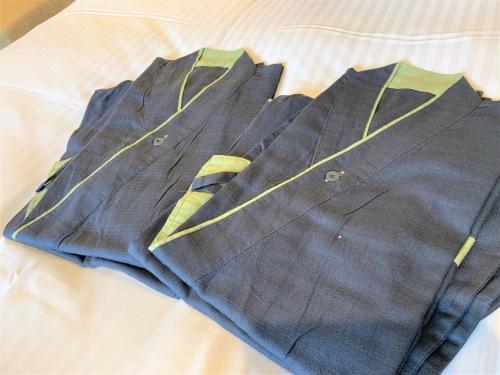 a blue shirt with yellow stripes on a bed at Almont Hotel Kyoto in Kyoto