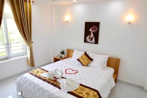 sypialnia z łóżkiem z białą pościelą i oknem w obiekcie Khách sạn Thái Bình w mieście Con Dao