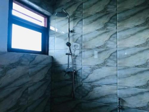 a bathroom with a shower with a glass door at Kandy IVY Banks Holiday Resort in Kandy