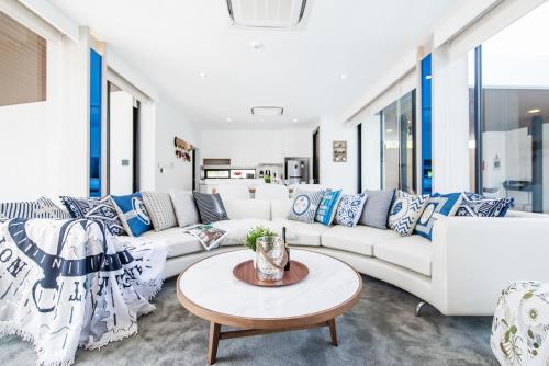 una sala de estar con sofás blancos y una mesa. en Movenpick Luxury Villa1FL-Private Pool-SHA CERTIFIED, en Na Jomtien