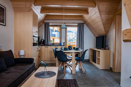 ein Wohnzimmer mit einem Sofa und einem Tisch mit Stühlen in der Unterkunft Tatrzanska Polana - Mountain View, Free Parking & WiFi in Zakopane
