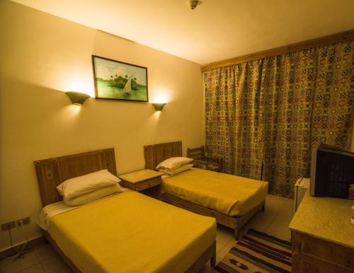 a hotel room with two beds and a television at Morgenland Holly Village in Saint Catherine