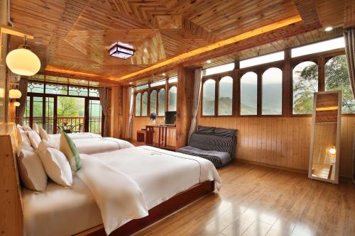 a bedroom with two beds in a room with windows at Longji Terrace La vie Inn in Longsheng