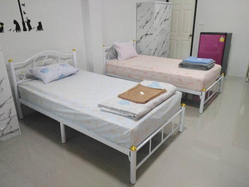 two twin beds in a room with at เพลินเพลิน​ วิลล่า in Sattahip