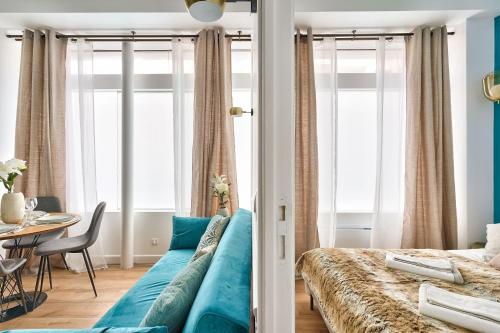 - une chambre avec un lit bleu et une table dans l'établissement NEWLY RENOVATED ! Stunning 2BR Apt in the Heart of Paris 15, à Paris