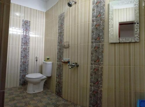 a bathroom with a toilet and a shower at HOTEL NAYORA PRABUMULIH in Prabumulih