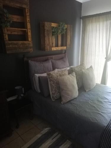 a bed with pillows on it in a bedroom at A-Cody Place in Louis Trichardt