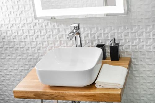 a white sink on a wooden counter in a bathroom at Feel like an Emperor Apartments in Split