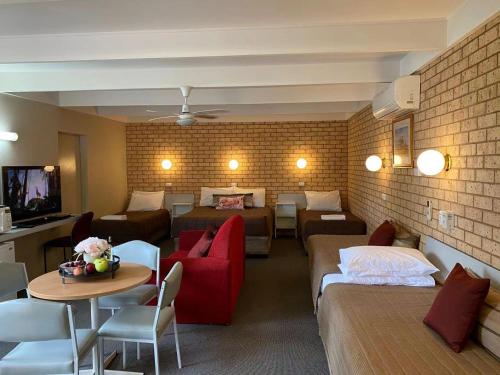 a hotel room with a couch and a living room at Apollo Motel Parkes in Parkes