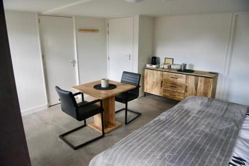 een slaapkamer met een tafel en stoelen en een bed bij De Slaapmuts in Winsum