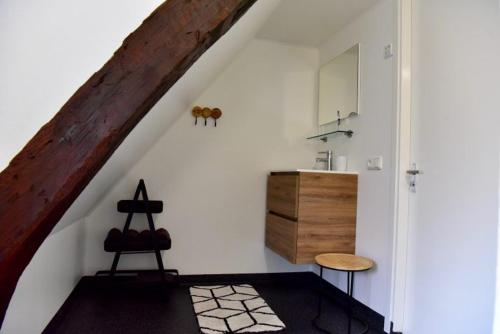 een kamer met een trap met een wastafel en een tafel bij De Slaapmuts in Winsum