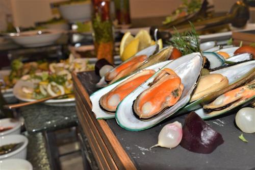 a buffet with plates of food on a table at Grand Millennium Tabuk in Tabuk